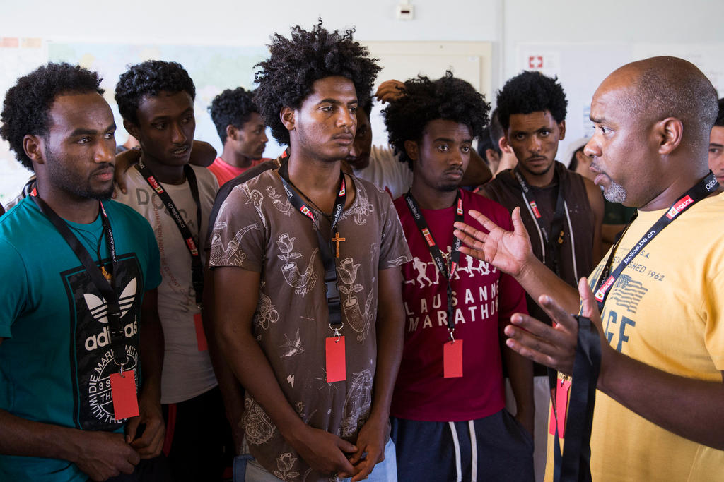An interpreter helps Eritrean asylum seekers during a Bern integration workshop