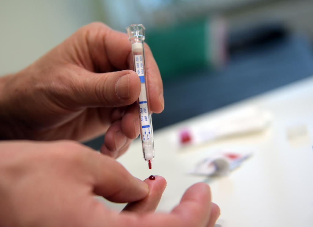 A picture of someone taking their own blood from their fingertip