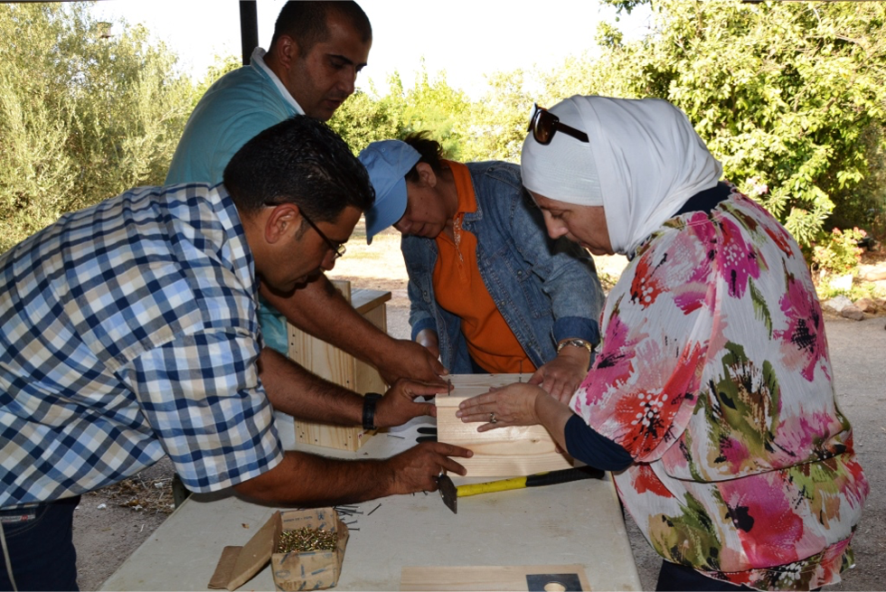 A group of people constructs barn owl nest boxes in Israel