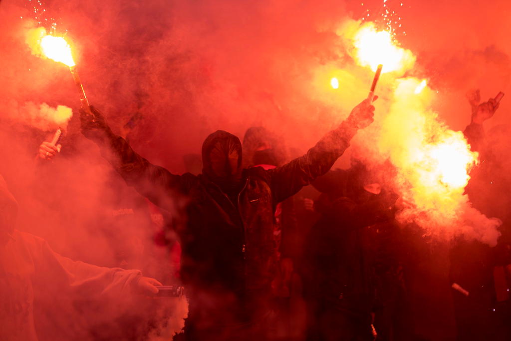Masked football hooligan holding flares