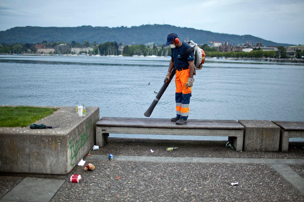 Man cleaning up litter by the lake