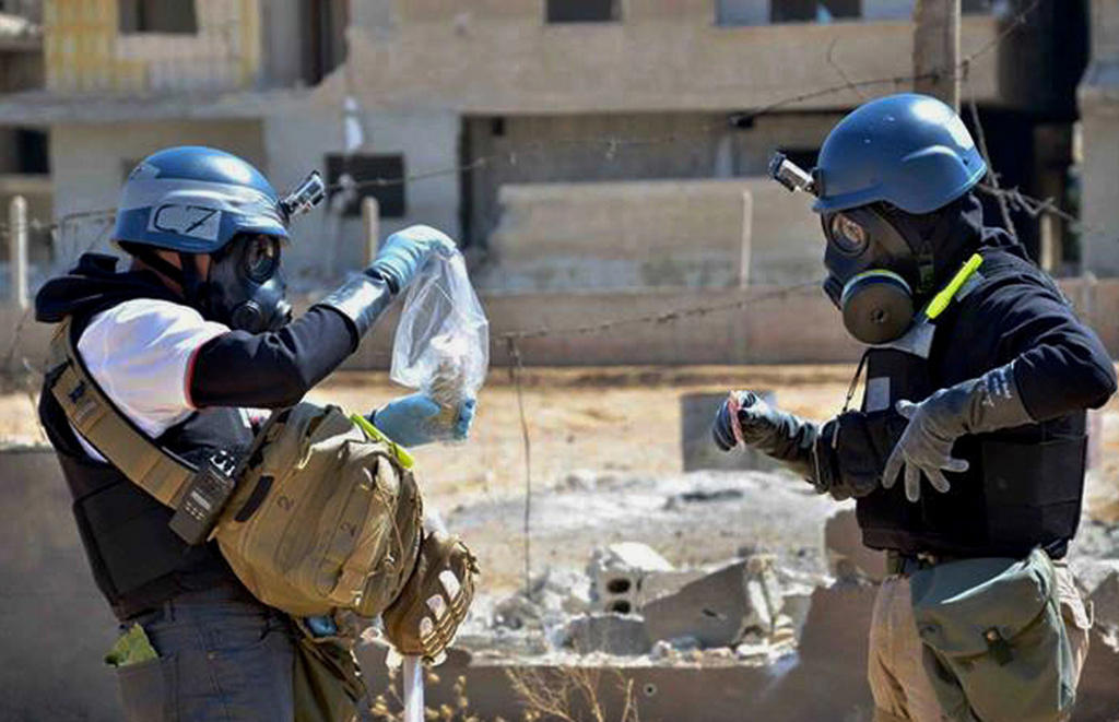 Investigators in Syria take samples from sand near a part of a missile that was suspected of carrying chemical agents.