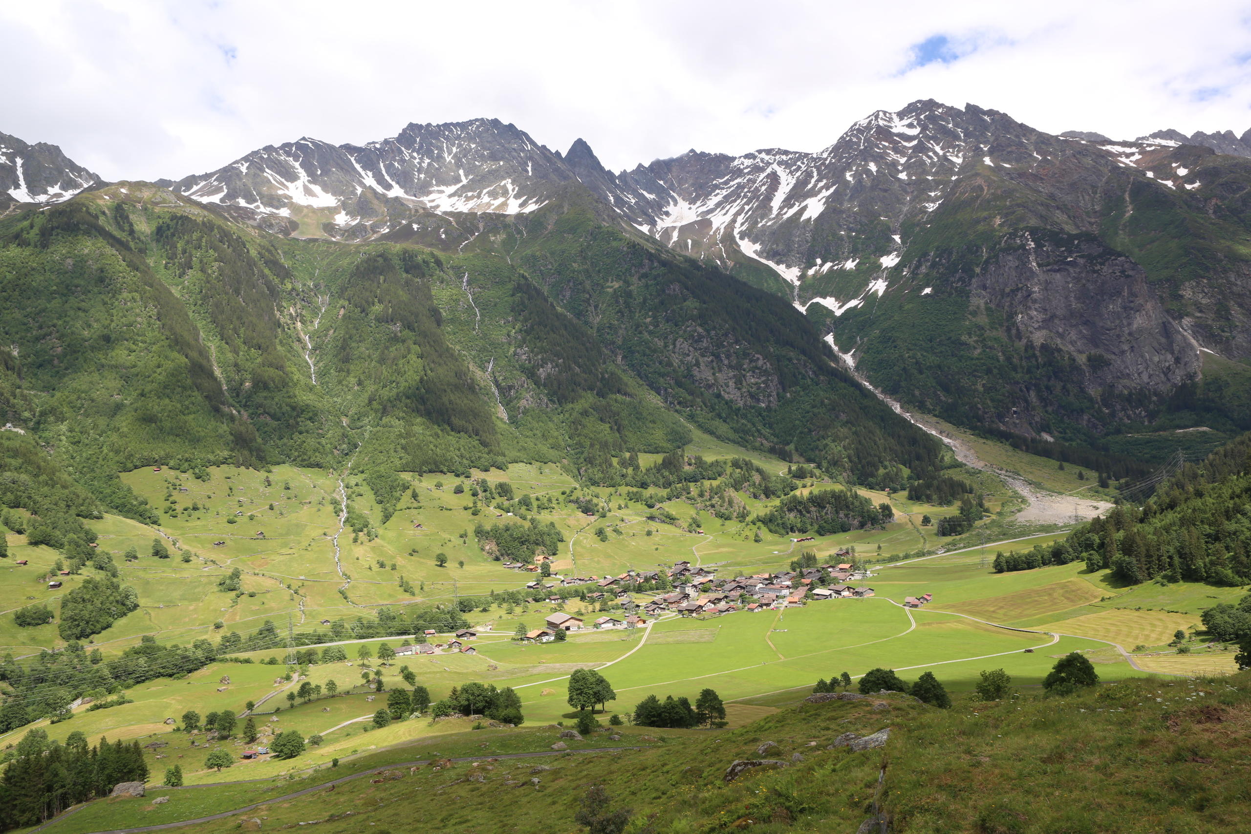 valley with a village surrounded by green mountains