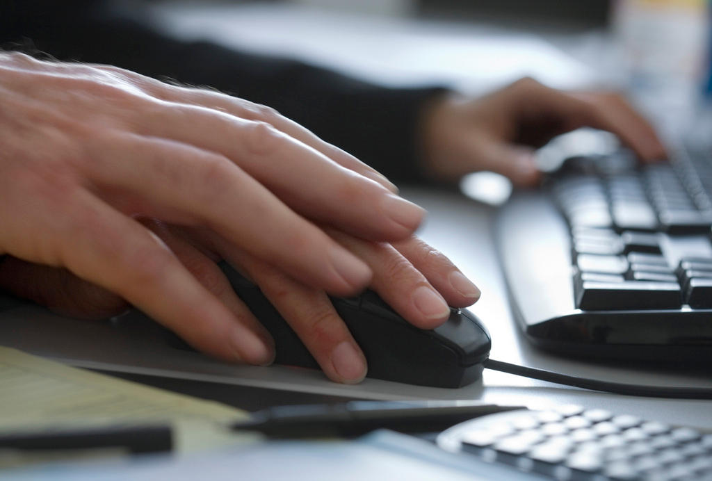 Two hands on a computer mouse