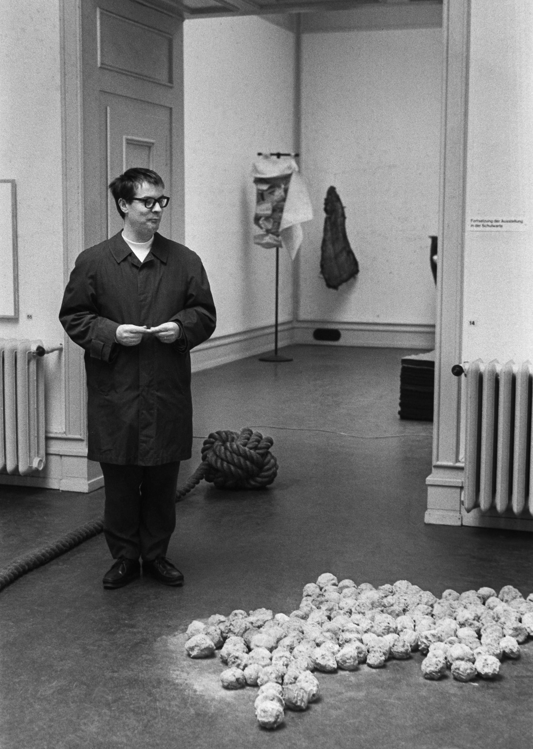 young man looks at art work on floor