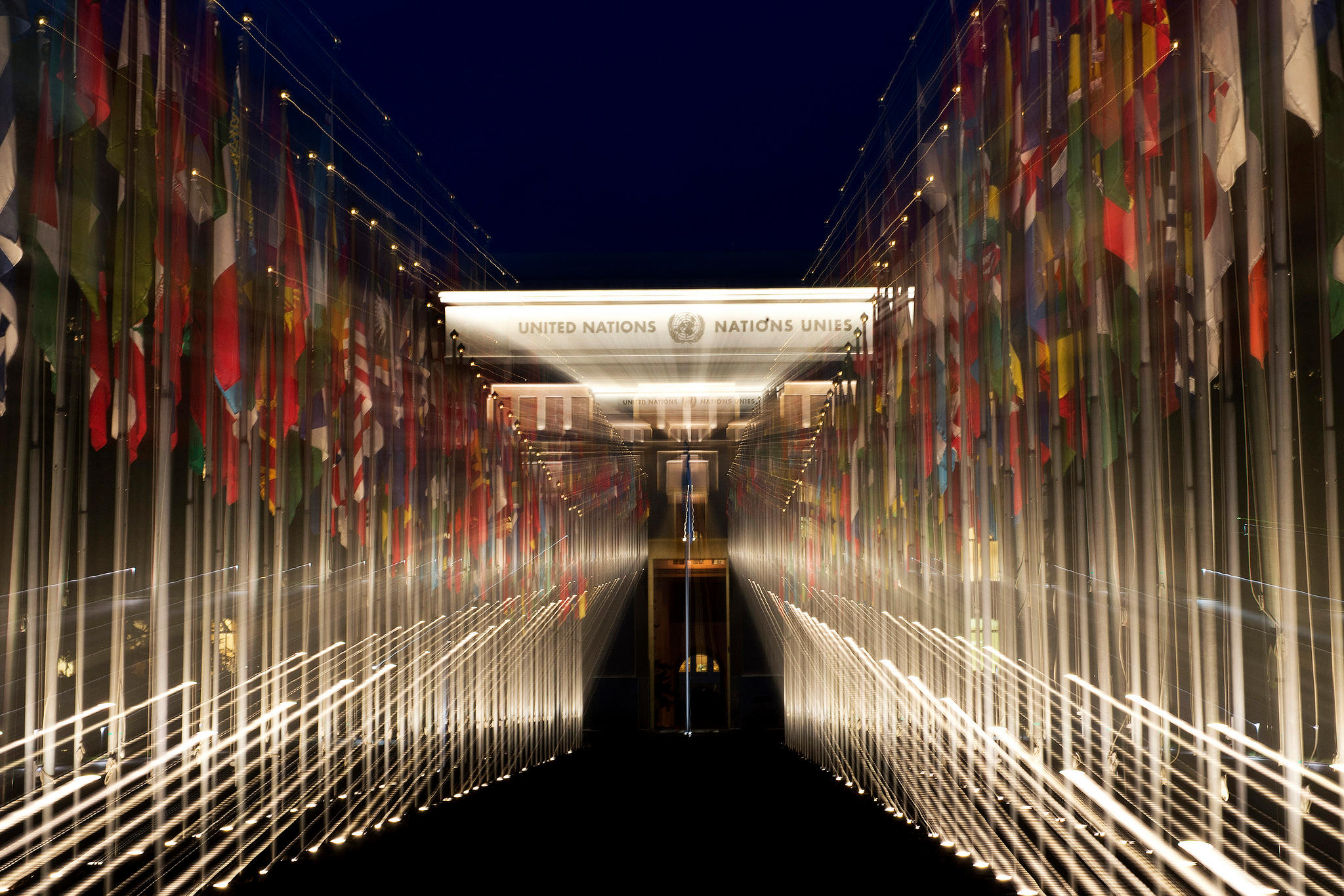 Lichtverzerrtes Bild von einer Allee aus Fahnenmasten.