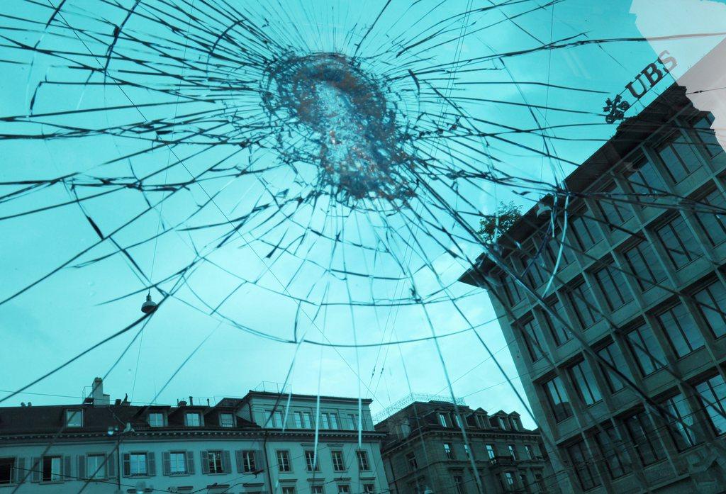 Blick auf Bankengebäude am Zürcher Paradeplatz durch eine zersprungene Glasscheibe