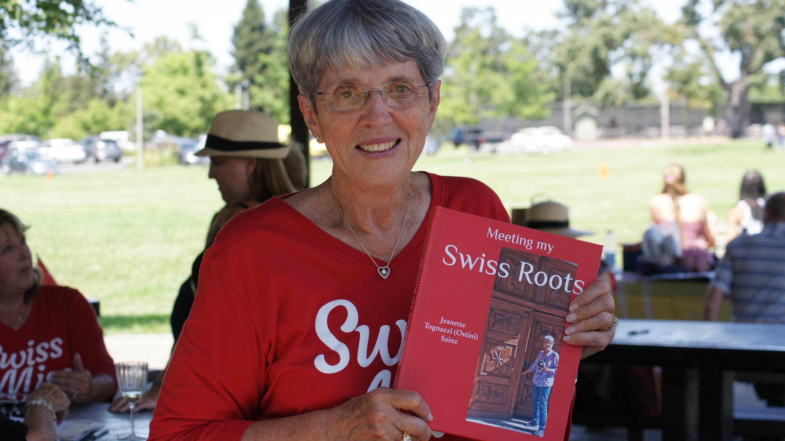 Jeanette holding up her Swiss Roots book