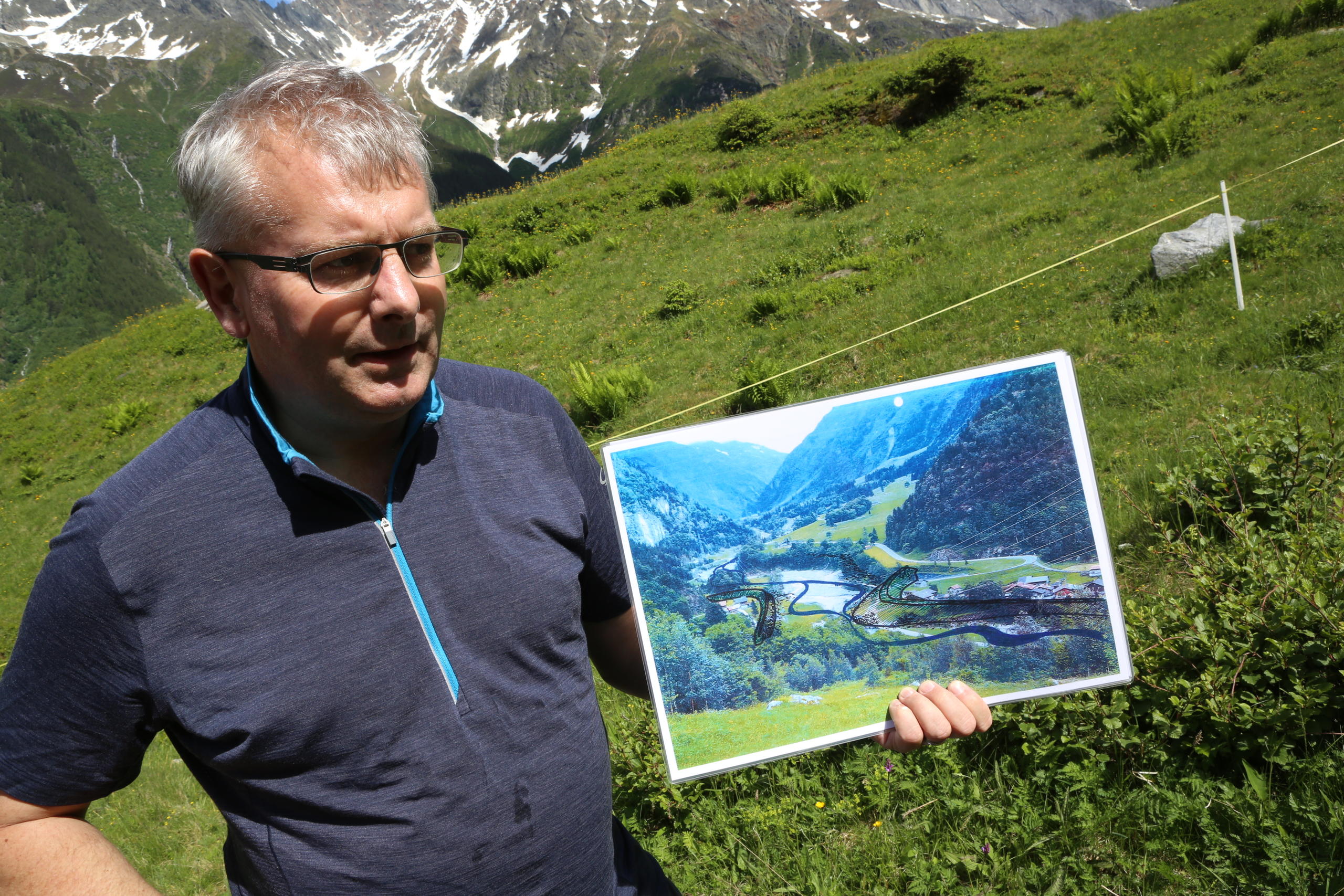 un uomo tiene in mano una fotografia di un fiume