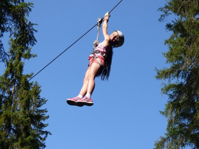 Child gliding between trees