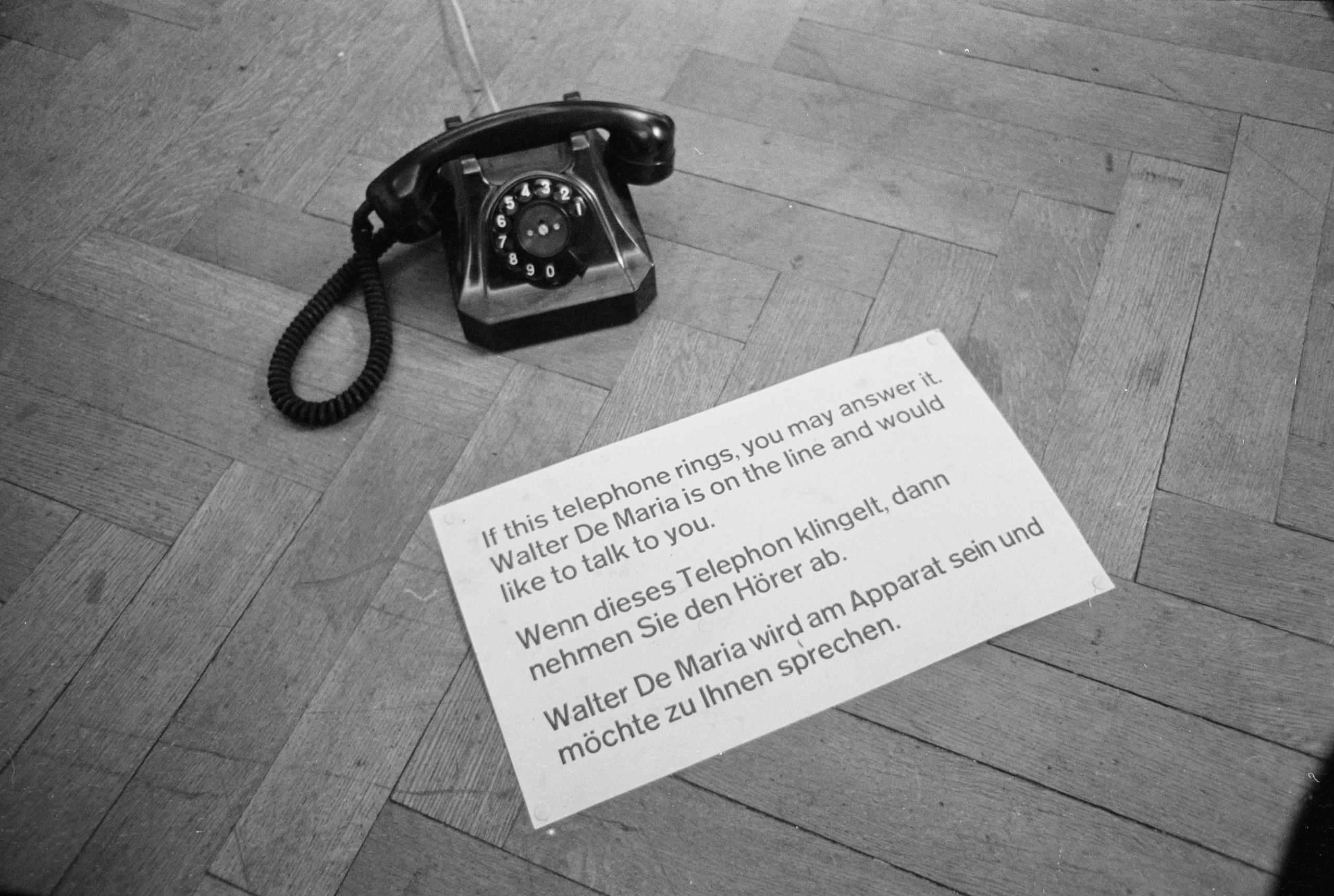 Aparelho antigo de telefone com folheto exposto no chão