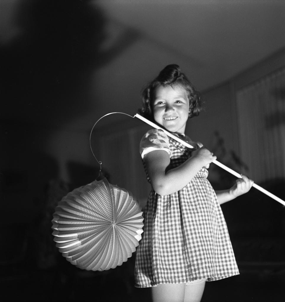 foto in bianco e nero di una bambina con una lanterna