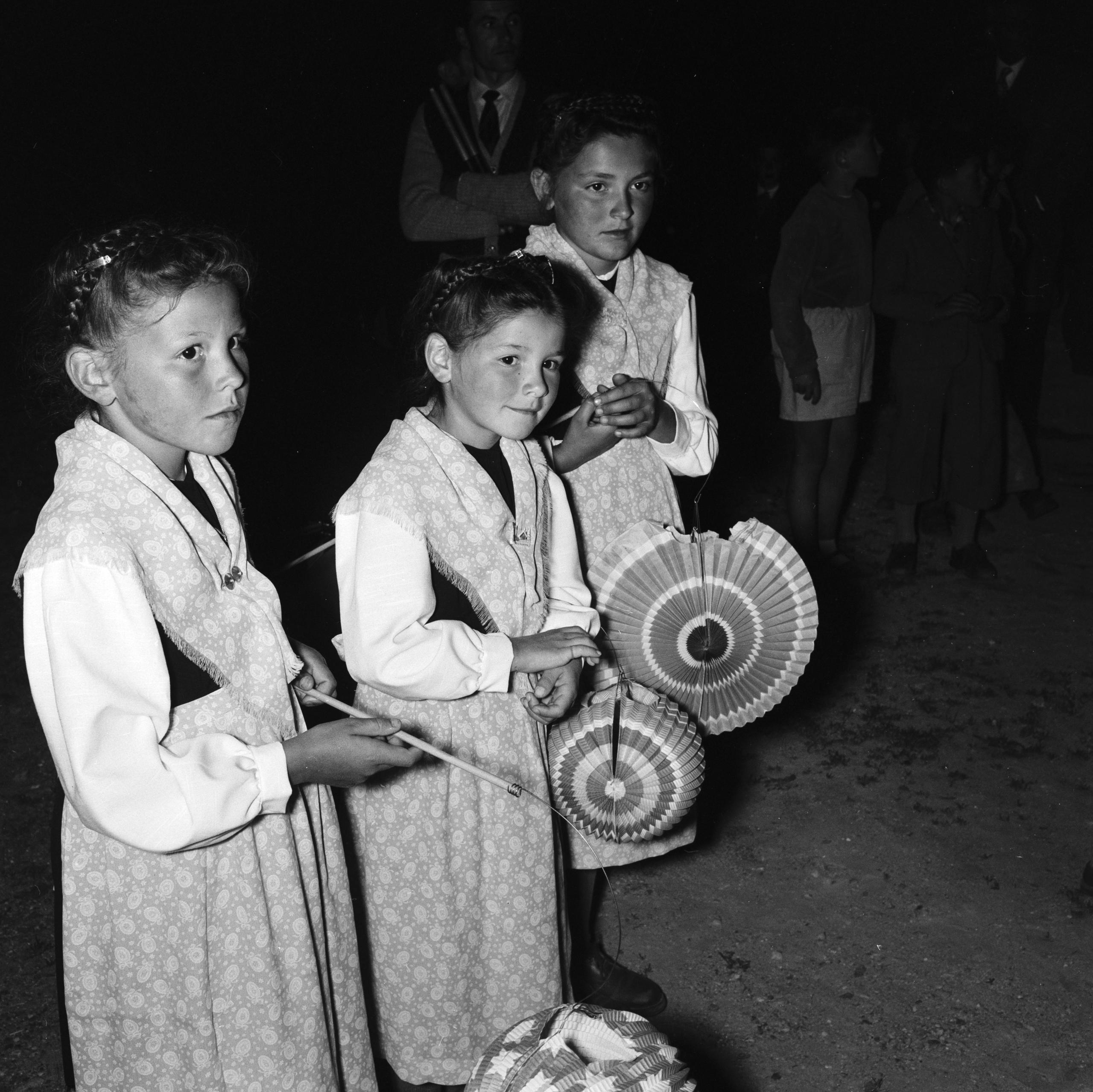 schwarz-weisses Foto von drei Mädchen mit Lampions an einem Fackelzug