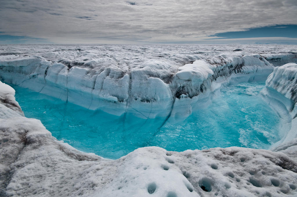 Surface melt water rushing through a supra-glacial stream channel in Greenland.