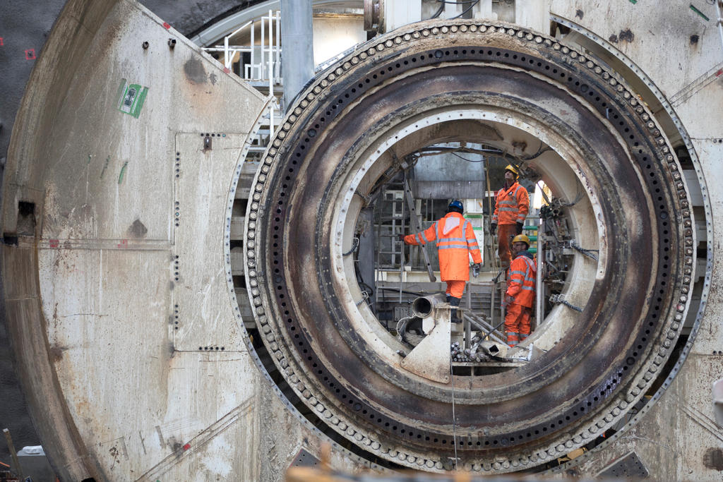 Tre operai in tuta arancione lavorano all interno di un tunnel