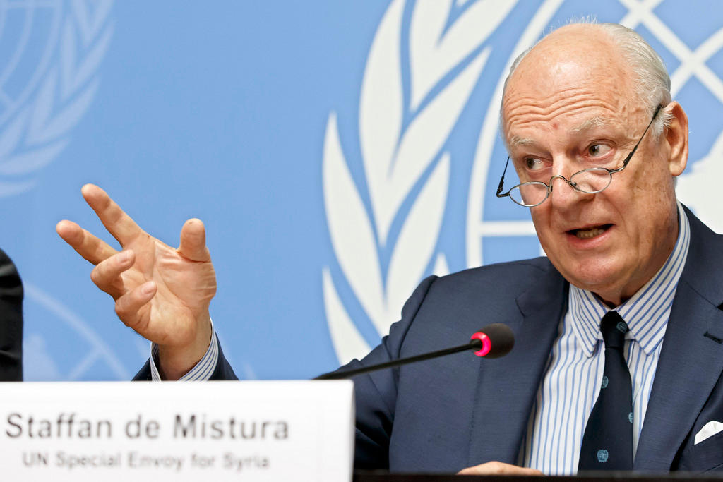Ein älterer Mann mit Brille sitzt vor dem UNO-Emblem und spricht in ein Mikrofon.