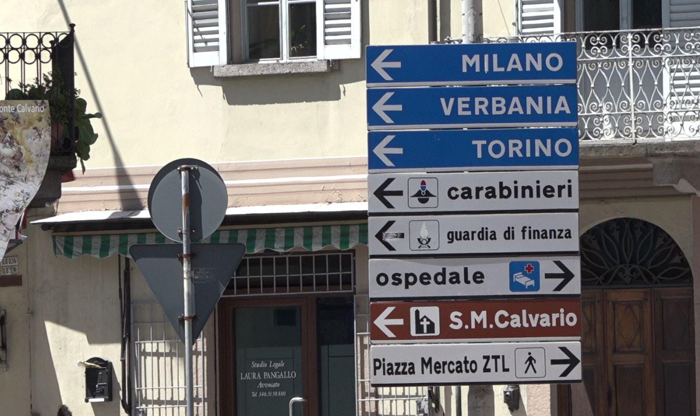Cartelli stradali nel centro di Domodossola: uno indica Milano e l altro Torino.