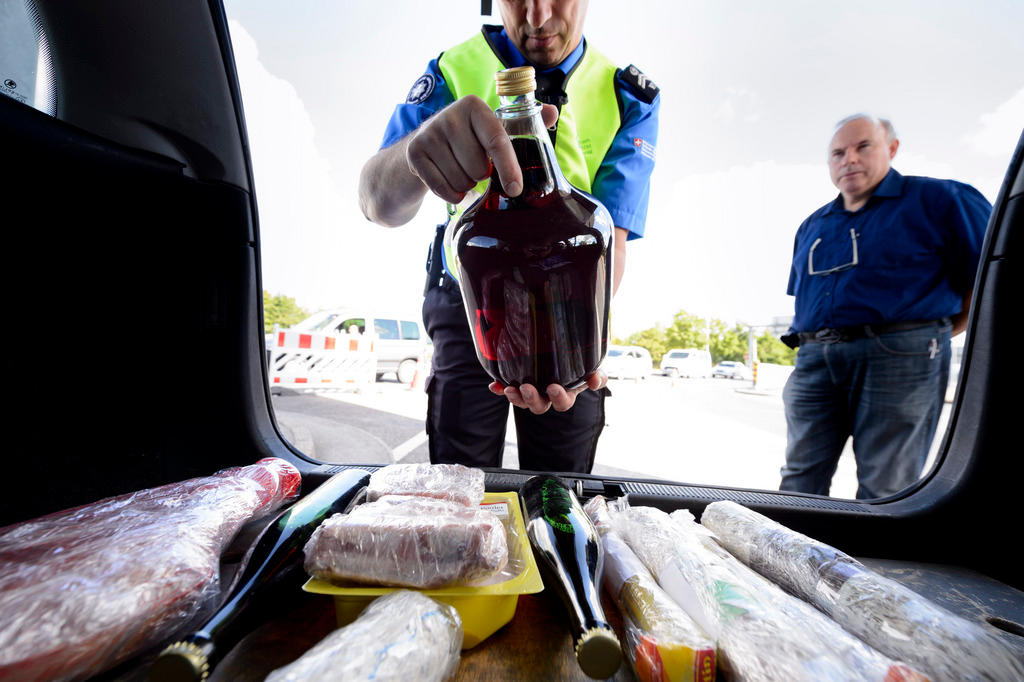 A customs officer inspects goods in a car boot as part of an exercise at the Bardonnex border post in Geneva in 2014