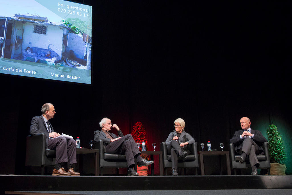 صورة لثلاث رجال وإمرأة يجلسون على منصة للحوار