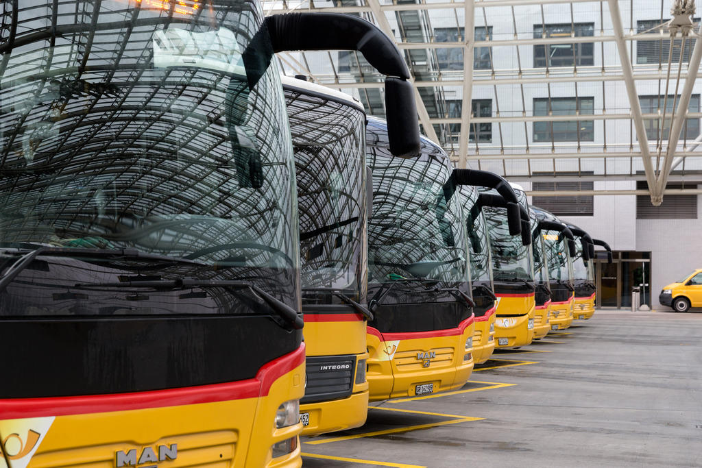 Row of yellow Swiss Post buses at a terminal