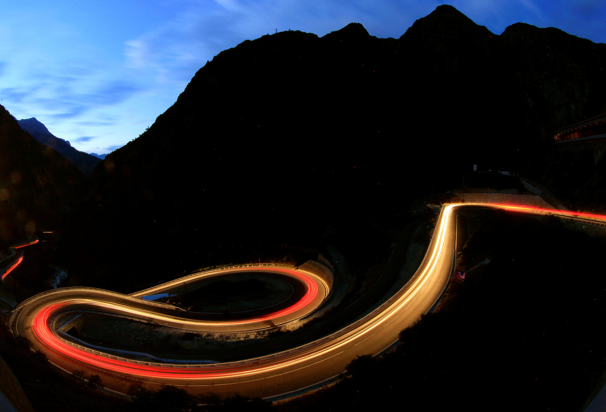 Langzeitbelichtung von Autolichtern nachts in Kurven der Schönllenenschlucht am Gotthard