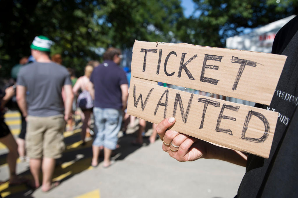 A man holds a Ticket Wanted sign at the Gurten music festival in Bern in 2014.