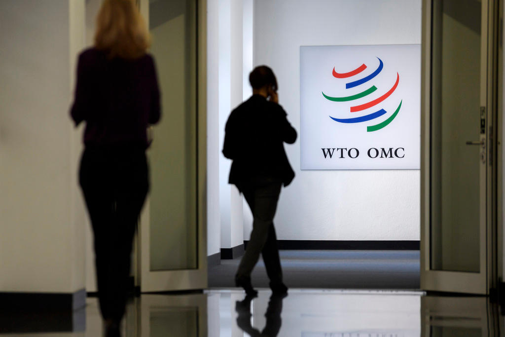 WTO employees walk the corridors with a WTO sign on the wall