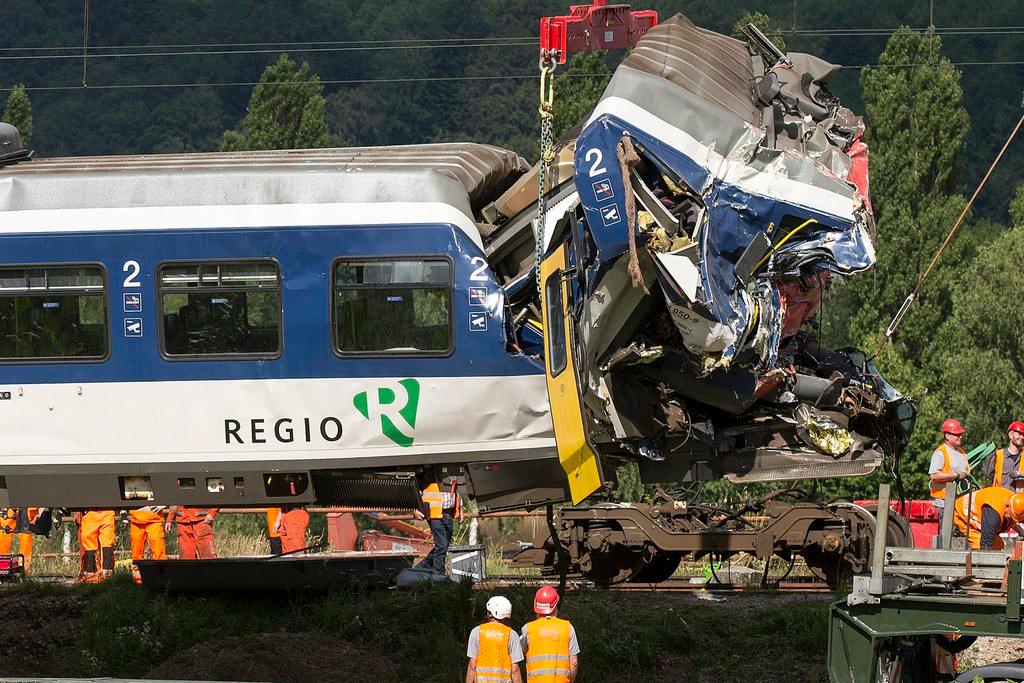 Swiss Federal Railways employees lift one of the trains after the collision, in Granges-pres-Marnand in 2013
