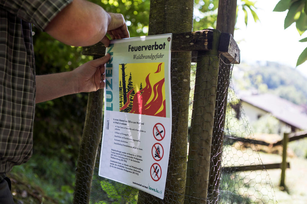 A man pins up a notice forbidding fires