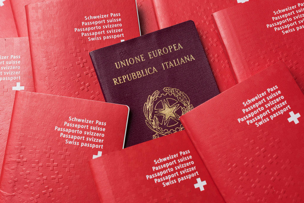 Un pasaporte italiano en medio de varios pasaportes suizos