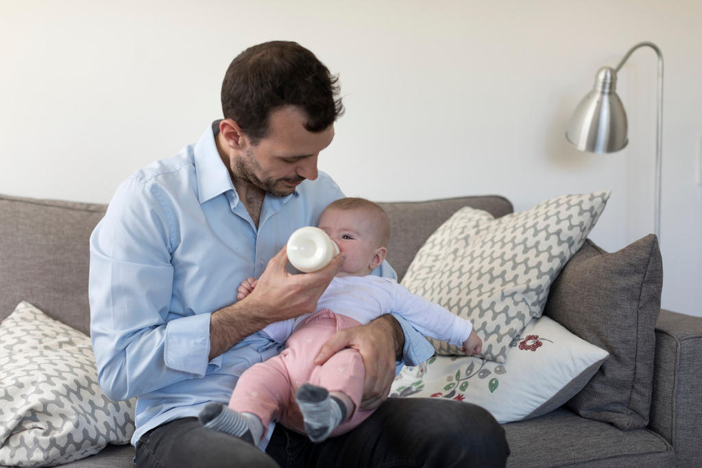 father feeding baby from a milk bottle
