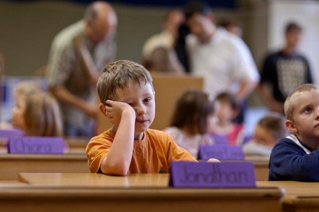 bambini seduti ai banchi di scuola.