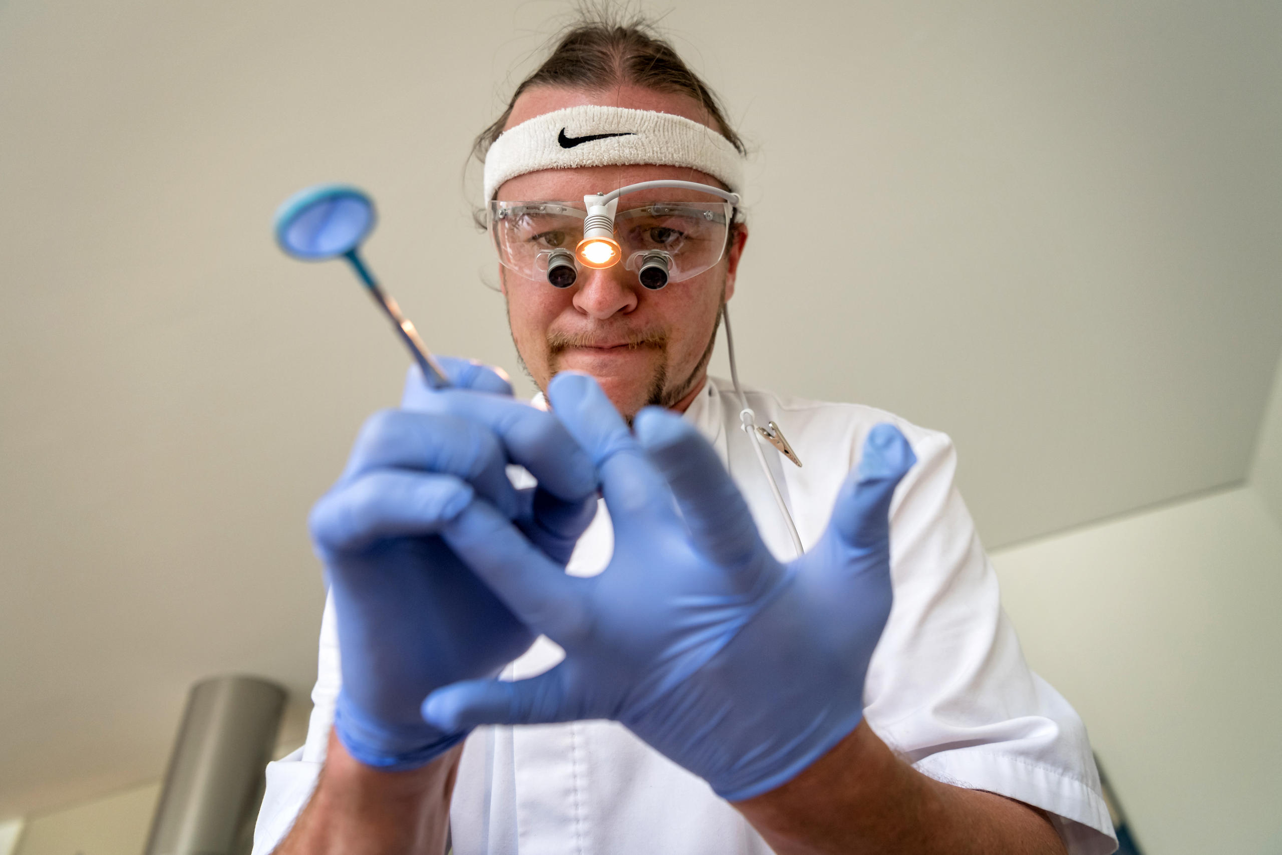 Le dentiste est en train de mettre des gants sur ses doigts