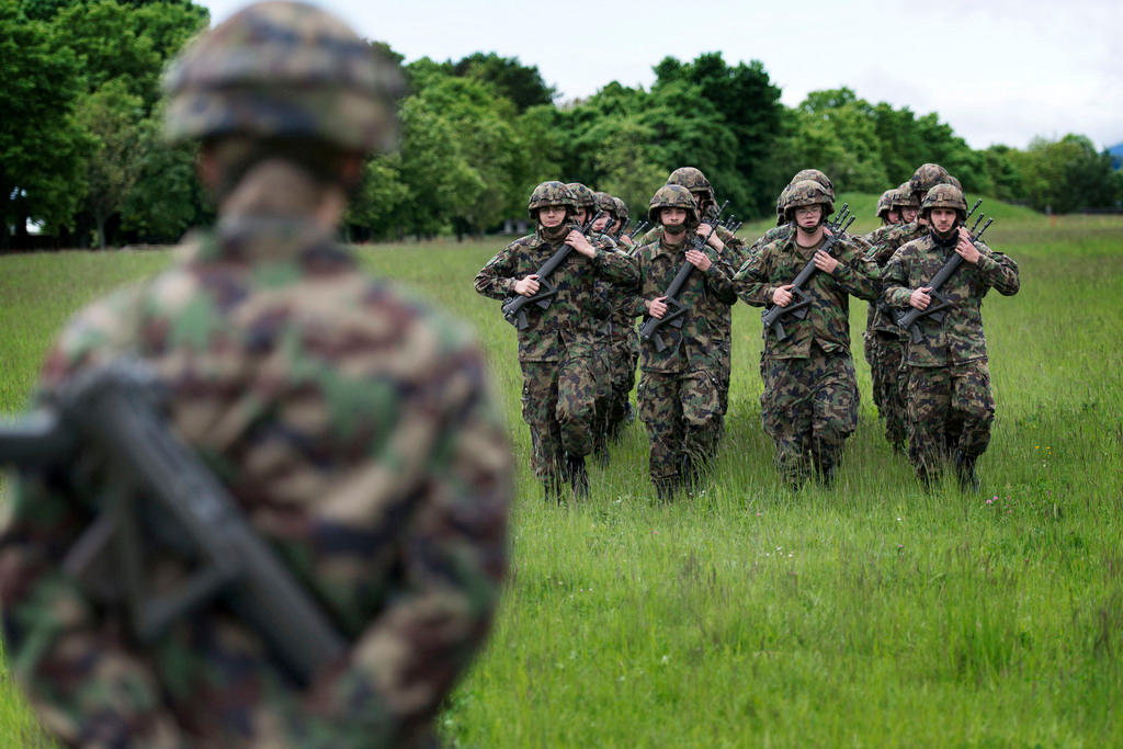 Swiss army infantry recruits at foot drill on a green field