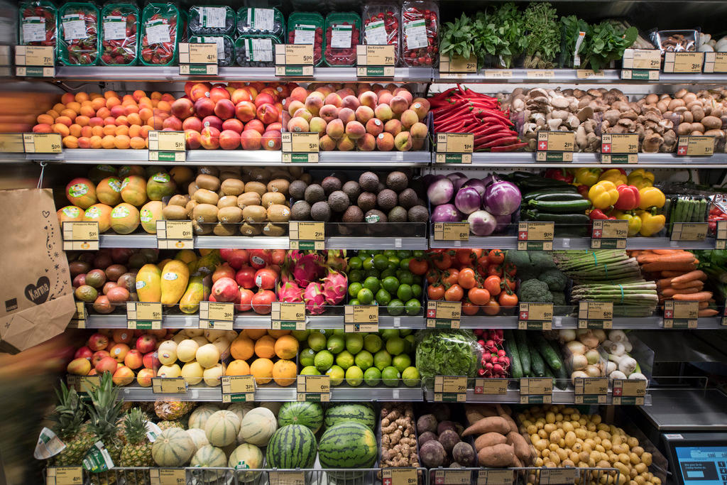 Un banco frutta-verdura verticale, con sei ripiani e una mezza dozzina di celle per piano; sacchetti sulla sx, bilancia a dx