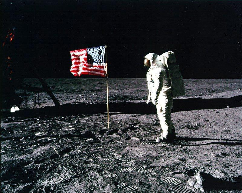 Apollo 11 astronaut Edwin Buzz Aldrin standing by the US flag planted on the surface of the moon