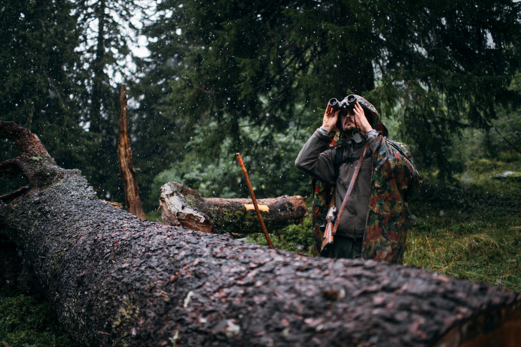 A hunter in Klosters looks through binoculars