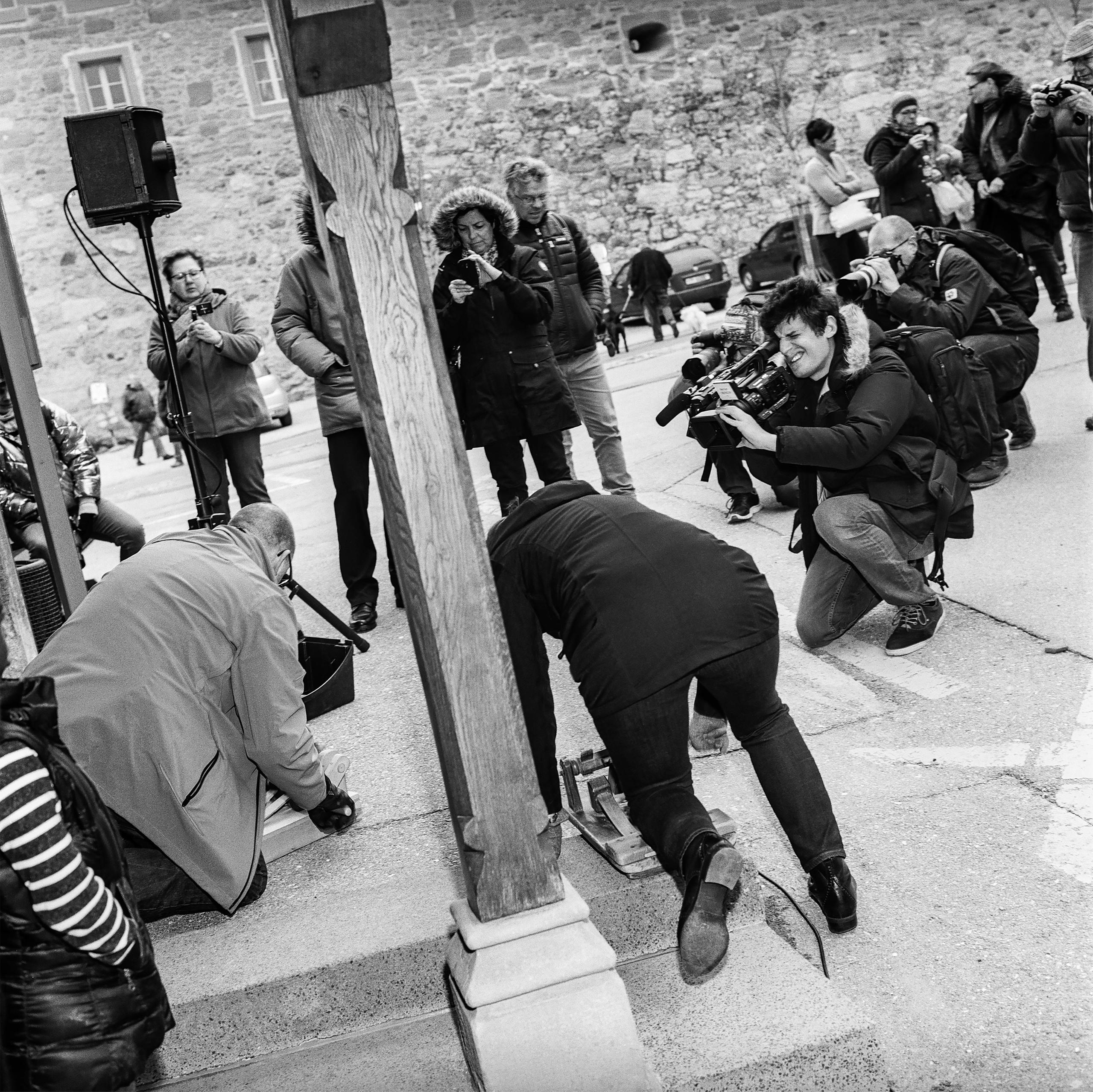 Fotografen und TV-Leute knien am Boden