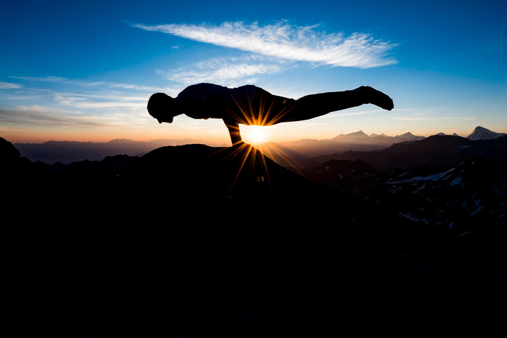 2018年8月2日星期四，瑞士瑜伽教师Emilien Badoux于旭日东升时分在位于瑞士内达兹(Nendaz)和韦尔比耶(Verbier)之间海拔高度为3329米的福特峰(Mont Fort)之巅做瑜伽练习。