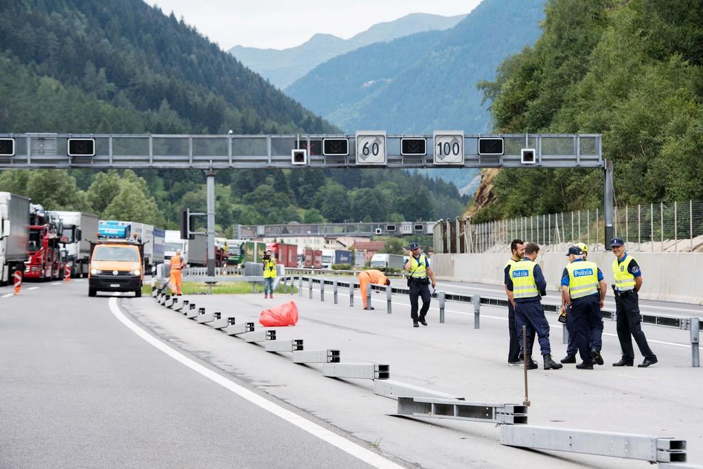 poliziotti in autostrada con alle spalle lunga fila di camion