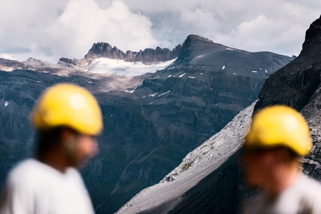 Construction workers with Alps in background