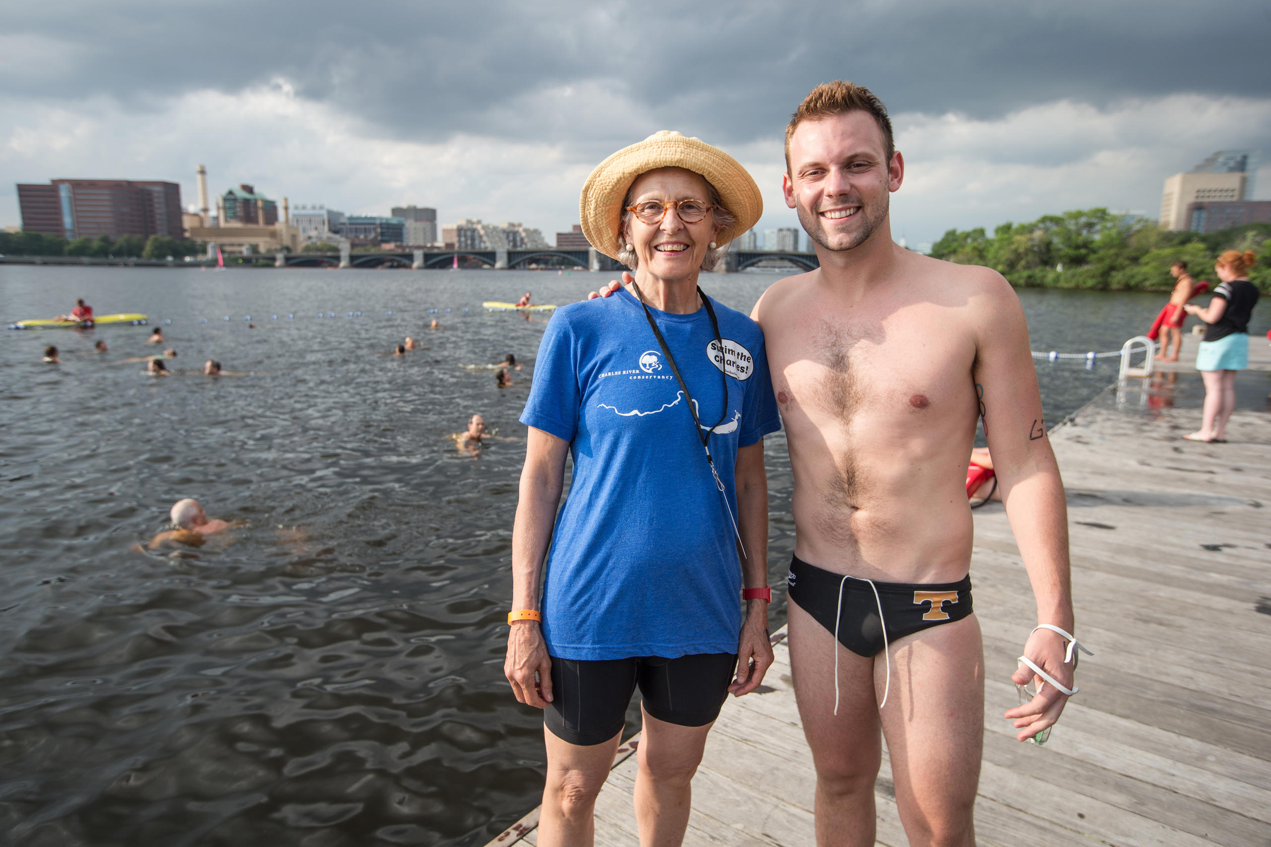 Woman and man photographed by the water with swimmers
