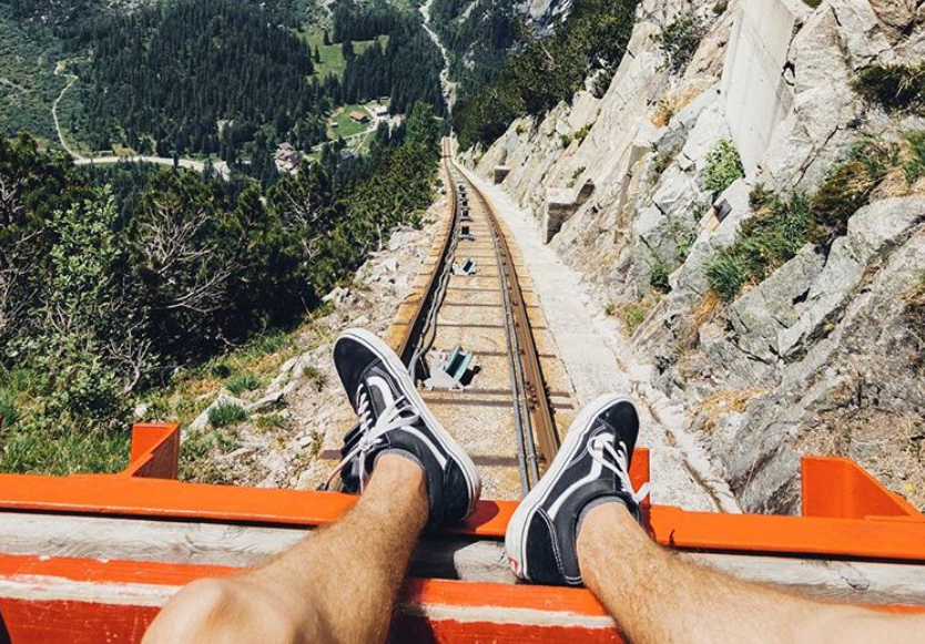 Looking down the tracks. Photographer has taken picture of his legs leaning over the front.
