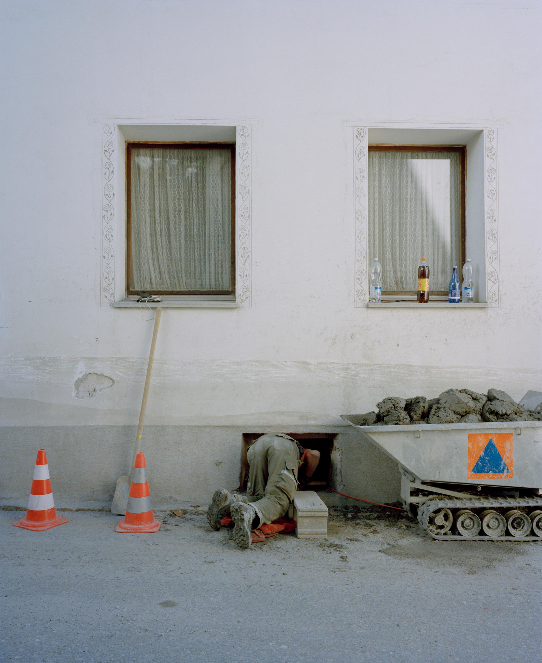 A person leaning from the outside into a cellar of a house