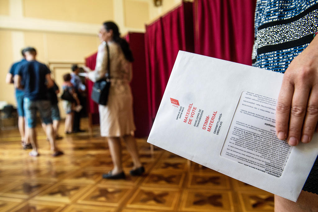 رجال ونساء يُدلون بأصواتهم في مكتب اقتراع