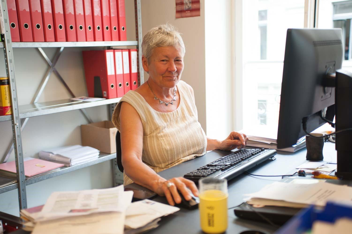 Mulher sentada à mesa na frente de um computador