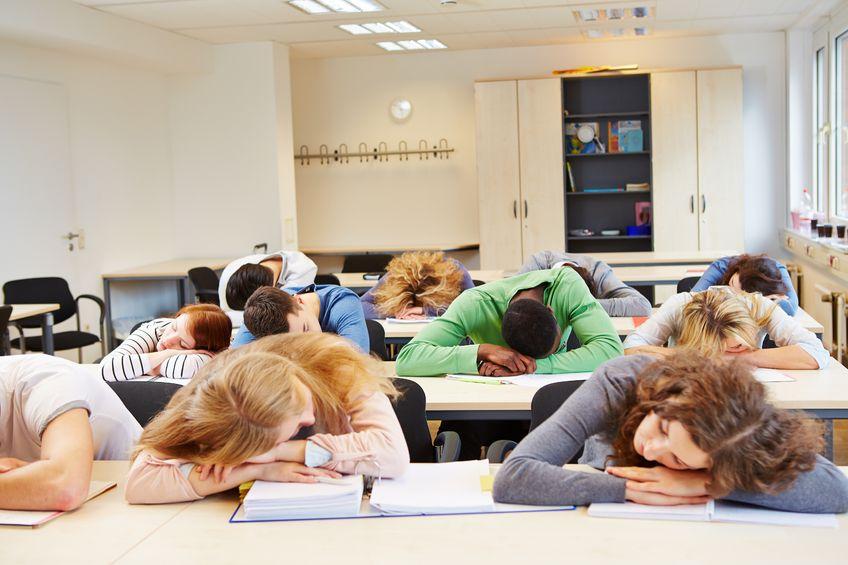 students with their heads down on their desks