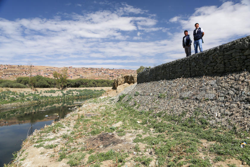 Two men on a wall over a river