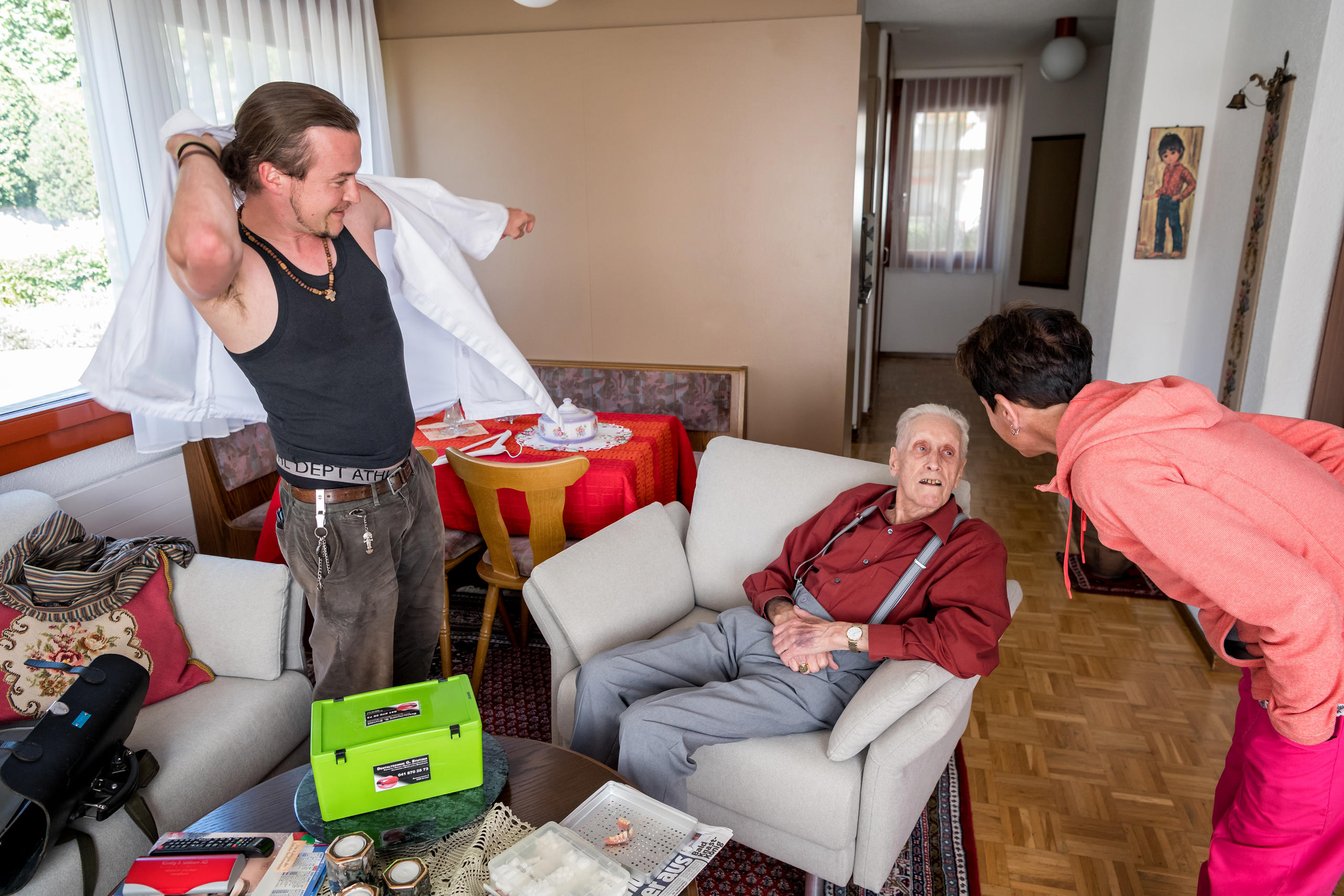 Im Altersheim, der Zahnarzt zieht sich eine weisse Schürze an