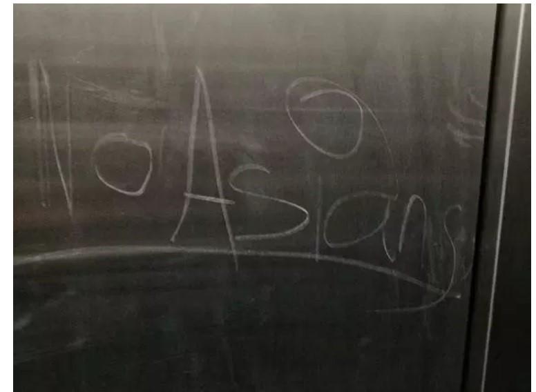Words No Asians written on blackboard